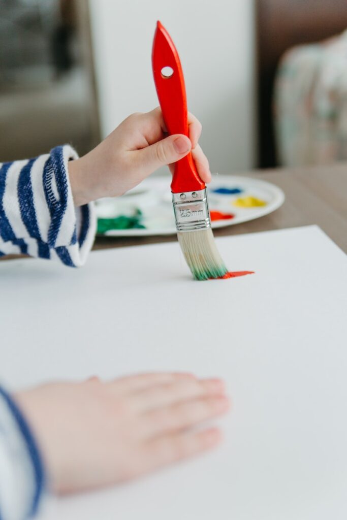 A Child Painting using a Paintbrush